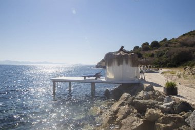 Bambu çatı ve küçük bir iskele üzerinde bir kaç beyaz bungalov