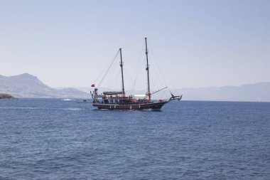 Sakin denizde arkadaki turist ile güzel bir yat yelken