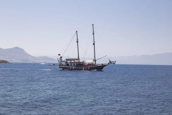 Sakin denizde arkadaki turist ile güzel bir yat yelken