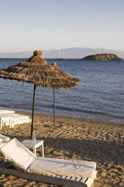 üzerinde plaj sandalyeleri plaj bambu şemsiyeleri altında birkaç beyaz