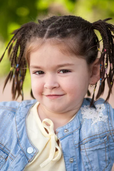 Porträtt av leende liten flicka med mörka ögon, frisyr i f — Stockfoto