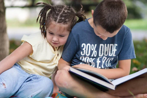 sevimli küçük kız at kuyruklu ve bir çocuk mavi T-shirt okuyun