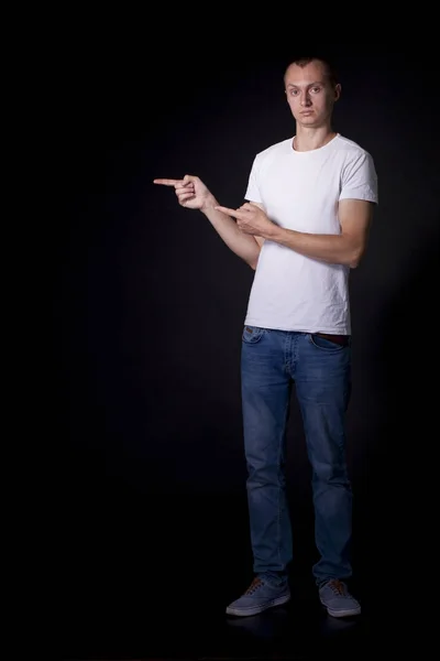 On a black background an ordinary young man with a short haircut — Stock Photo, Image