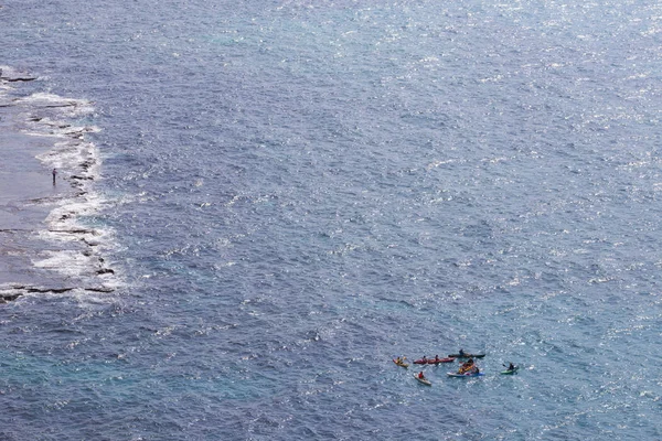 Une vue de loin sur la mer, le long de laquelle plusieurs kayaks colorés — Photo