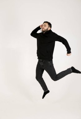 çekici bir genç adam siyah giysili küçük sakallı atlamak