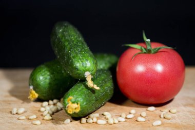 bir olgun kırmızı domates, yatay bir görüntüsünü üç salatalık ve bir