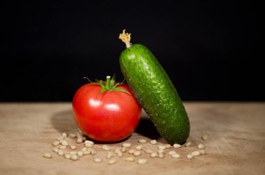 Olgun kırmızı domates ve se bir avuç yanında bir yeşil salatalık