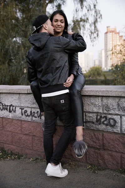 Couple in love: a beautiful young girl in a black leather jacket