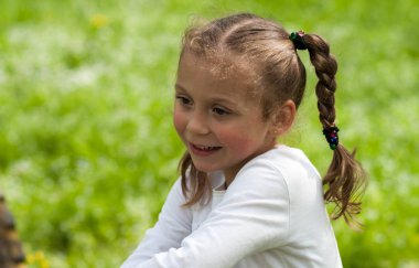 güzel bir anlatım beş yaşındaki kızın iri yeşil gözleri ve yeşil alan Park bulanık bir arka plan üzerinde komik bezleri şeklinde bir saç kesimi ile duygular