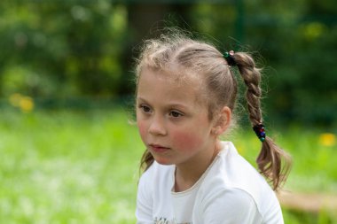 güzel bir anlatım beş yaşındaki kızın iri yeşil gözleri ve yeşil alan Park bulanık bir arka plan üzerinde komik bezleri şeklinde bir saç kesimi ile duygular