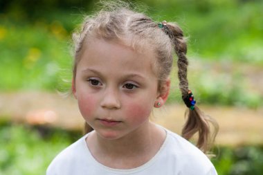 güzel bir anlatım beş yaşındaki kızın iri yeşil gözleri ve yeşil alan Park bulanık bir arka plan üzerinde komik bezleri şeklinde bir saç kesimi ile duygular