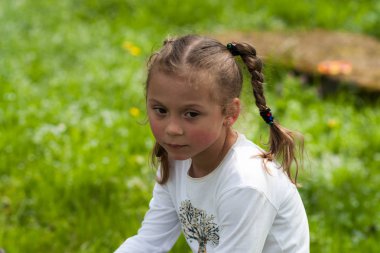 güzel bir anlatım beş yaşındaki kızın iri yeşil gözleri ve yeşil alan Park bulanık bir arka plan üzerinde komik bezleri şeklinde bir saç kesimi ile duygular