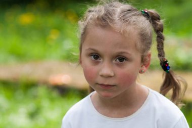 güzel bir anlatım beş yaşındaki kızın iri yeşil gözleri ve yeşil alan Park bulanık bir arka plan üzerinde komik bezleri şeklinde bir saç kesimi ile duygular