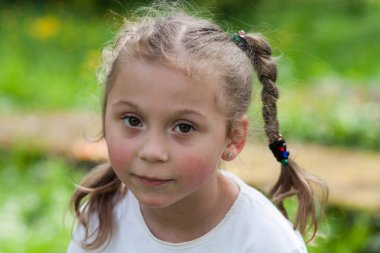 güzel bir anlatım beş yaşındaki kızın iri yeşil gözleri ve yeşil alan Park bulanık bir arka plan üzerinde komik bezleri şeklinde bir saç kesimi ile duygular