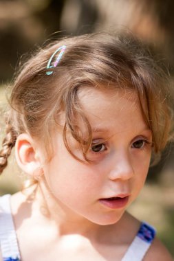 güzel bir anlatım beş yaşındaki kızın iri yeşil gözleri ve yeşil alan Park bulanık bir arka plan üzerinde komik bezleri şeklinde bir saç kesimi ile duygular