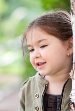 güzel bir park ve yeşil renk arka plan bulanık üzerinde komik bezleri şeklinde bir saç kesimi ve beş yaşındaki kızla ifade duyguların
