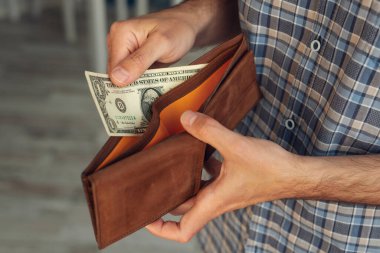 Bir adamın eli, cüzdanında 1 Amerikan Doları 'nı çıkardı.