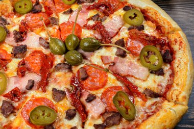 Jalapeno biberli pizza, pastırma ve pepperoni, yakın plan.