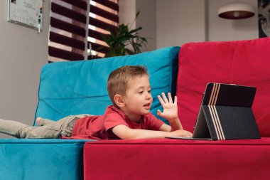 Küçük bir çocuk uzaktan tablet kullanarak iletişim kuruyor.