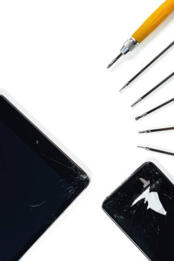 Kırık tablet ve akıllı telefonun bir parçası, tamir için bir takım araçlar