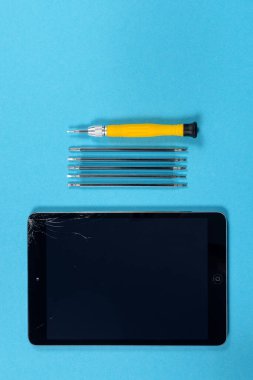 Tablet onarım konsepti. Kırık tablet ve mini tornavida.
