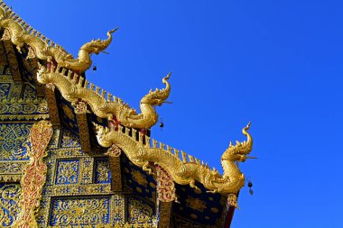 Sağ çatı, Wat Rong Sua Ten, Chiang Rai, Tayland - Budist Tapınağı, Dış yapı tasarımı ve Asya sanatında açık mavi gökyüzü ile bezenmiş Tayland tarzı ann çizgisi ile süslenmiştir.  