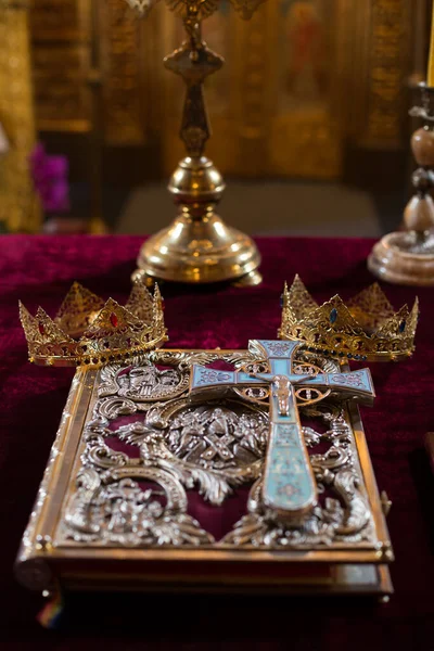 Bible with cross and wedding crowns