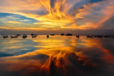 Sahilde gün batımı, tekneler ve turuncu gökyüzü. Koh Tao, Tayland.