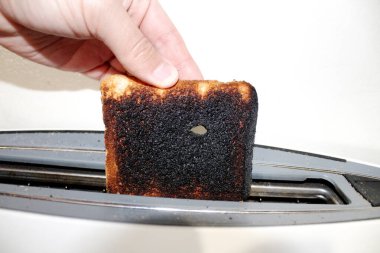 Tost makinesinden yanmış tostu çıkarıyorum.