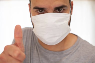 Çok iyimser ve pozitif koronavirüs maskeli bir adam.