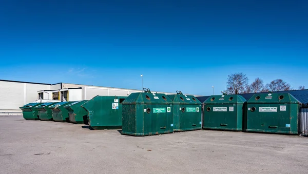 Park yerindeki büyük umumi geri dönüşüm istasyonu farklı ev atıklarını atmak için - plastik, metal, kağıt, karton. Kuzey İsveç, Umea. Güneşli bir gün. Yeşil metal kaplar sıralanmış geri dönüşüm