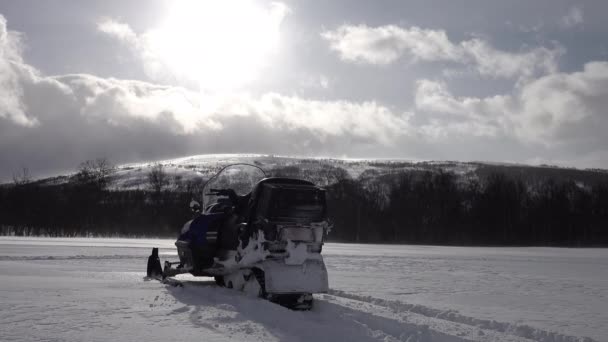 Skuter Śnieżny Bez Kierowcy Stoi Przed Białym Polem Śnieżnym Górą — Wideo stockowe