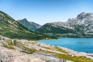 Norveç 'teki sakin körfeze bakın, Nesna ve Maela köyleri arasında, Atlantik okyanusunun mavi suyu, dağlar, sakin güneşli yaz günü Norveç
