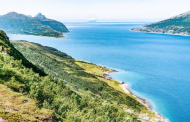 Norveç 'in sakin körfezindeki yüksek noktadan, Nesna kasabası yakınlarındaki Hugla adasından Donna' nın arkasında bıraktığı Atlantik Okyanusu 'nun mavi sularında, sakin güneşli yaz günü Norveç' e bakın..