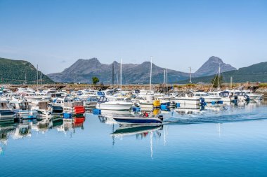 Nesna, Norveç - 06 Ağustos 2019: Motorlu tekne Nesna marinasının önünde sürüyor: sakin mavi okyanusta sürücüler, yelkenliler, balıkçı tekneleri. Nesna 'ya yolculuk, güneşli sakin bir yaz günü, Norveç