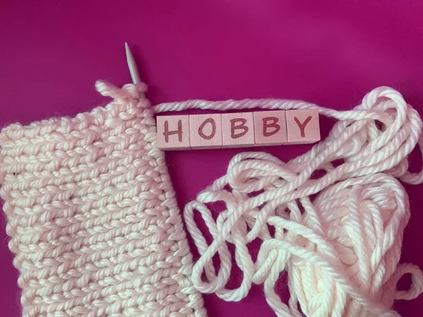 yarn and thread on a pink background, the Concept of a hobby