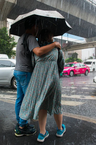 Bangkok Tayland ve 10.10.10.2019 şiddetli yağmur çiftleri yolu geçmeye çalışıyorlar.