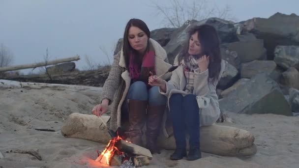 dvě ženy, posezení u ohně. Piknikový gril