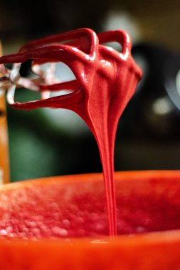 Kırmızı hamurun çırpıcıdan portakal kabına düşme hazırlığı