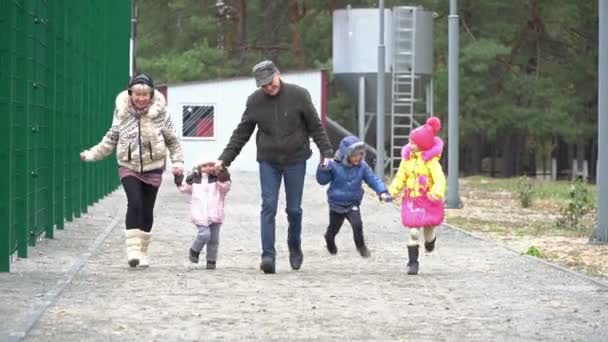 Бабушка с дедушкой и внуки бегут — стоковое видео