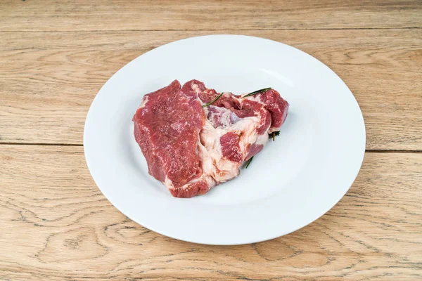 Kawałka surowego mięsa na talerzu — Zdjęcie stockowe