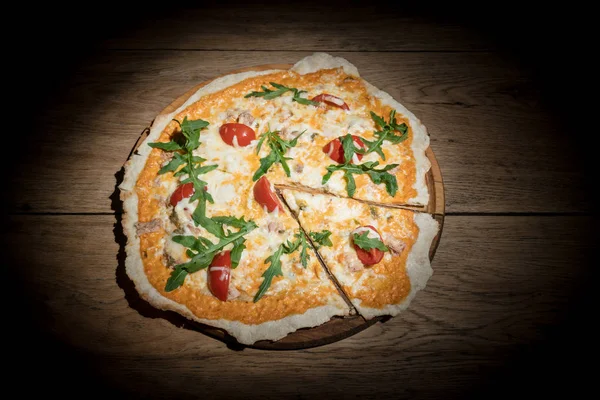 Пицца с тунцом в темноте — стоковое фото
