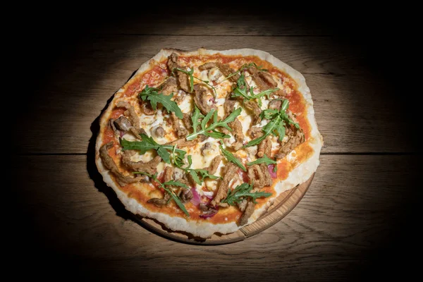 Свиная пицца с грибами в темноте — стоковое фото