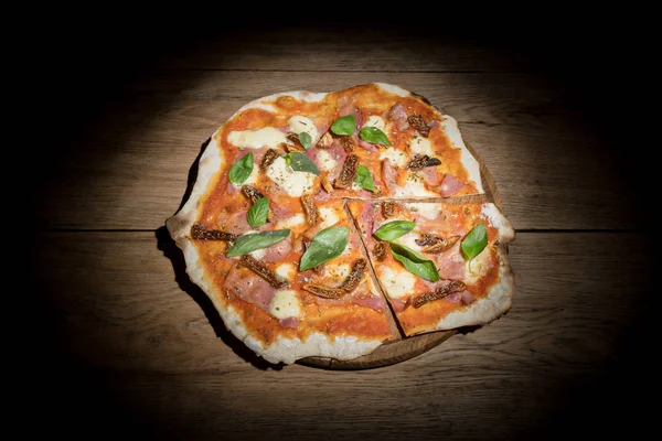 Пицца с инжиром, нарезанный кусок, в темноте — стоковое фото