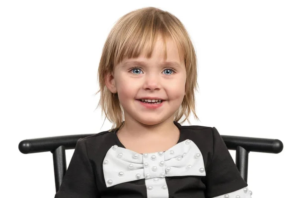 Leende liten flicka på en stol — Stockfoto