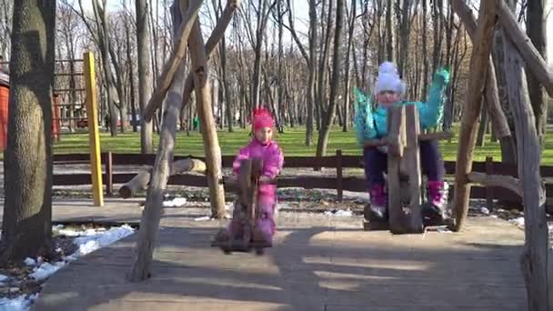 Two little girls on swing ride - horses — Stock Video