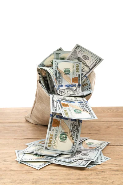 Dollars fall out of bag on table — Stock Photo, Image