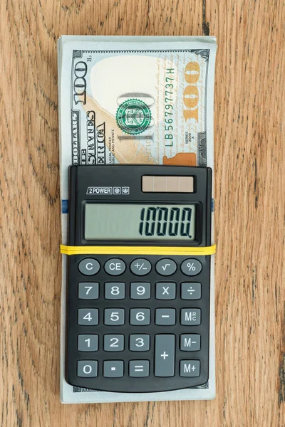 Calculadora en un paquete de dólares — Foto de Stock