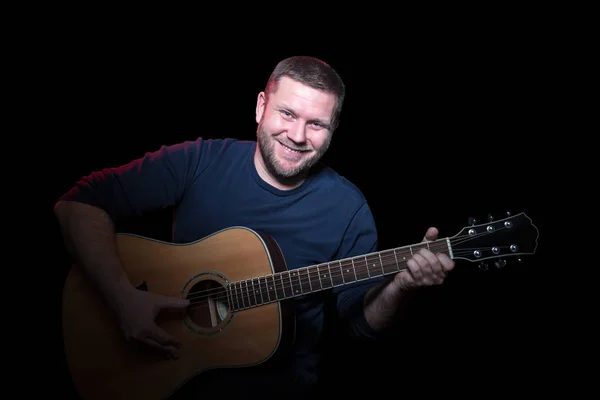 Portret van een glimlachende man met gitaar — Stockfoto