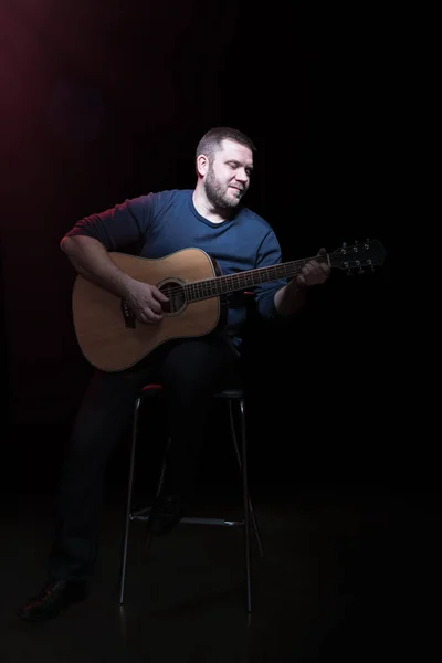 Portret van een bebaarde man met gitaar — Stockfoto